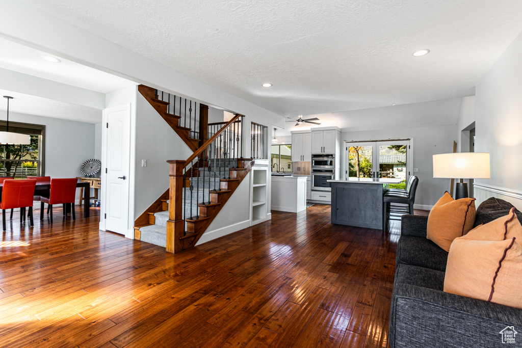 Living room with french doors, sink, dark hardwood / wood-style flooring, a textured ceiling, and ceiling fan