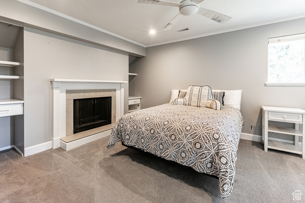 Carpeted bedroom with crown molding and ceiling fan