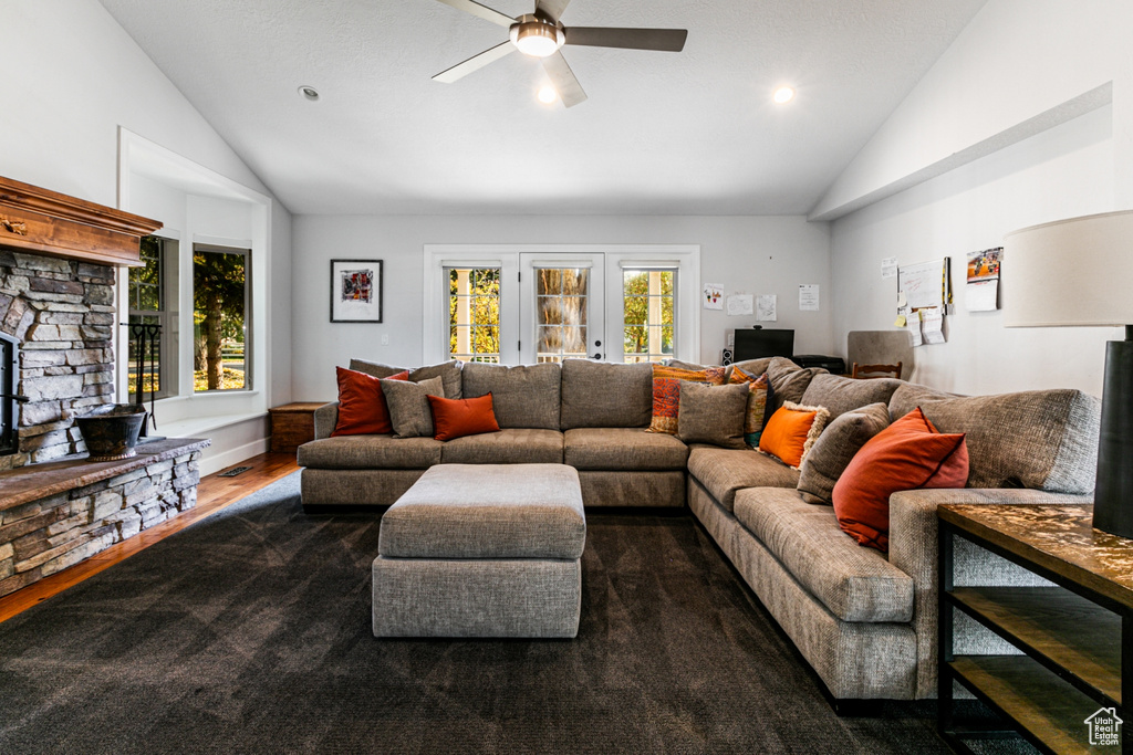 Living room with ceiling fan, vaulted ceiling, and dark hardwood / wood-style flooring