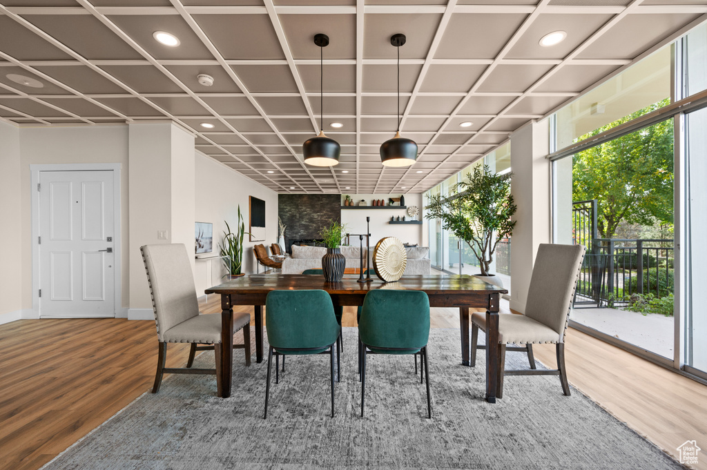 Dining space with coffered ceiling, hardwood / wood-style floors, and a healthy amount of sunlight