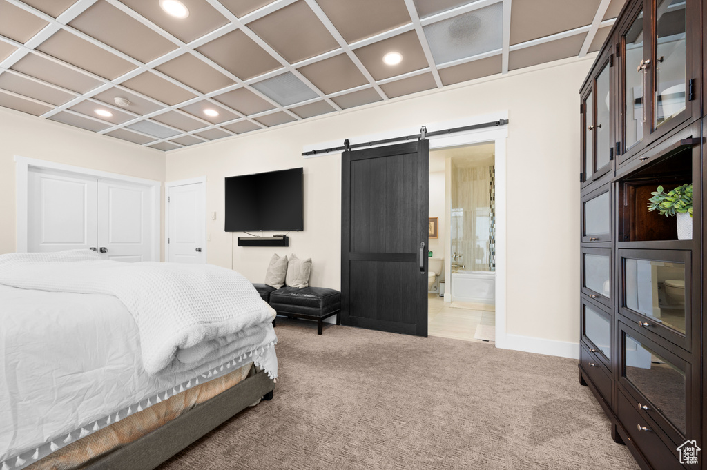 Bedroom with ensuite bathroom, carpet floors, a barn door, and coffered ceiling