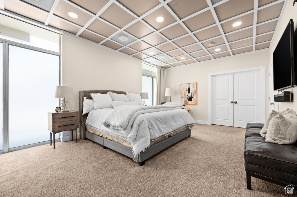 Bedroom with a closet, coffered ceiling, and carpet