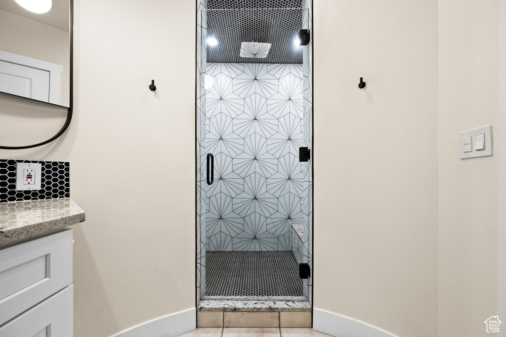 Bathroom with vanity, tile patterned floors, and an enclosed shower