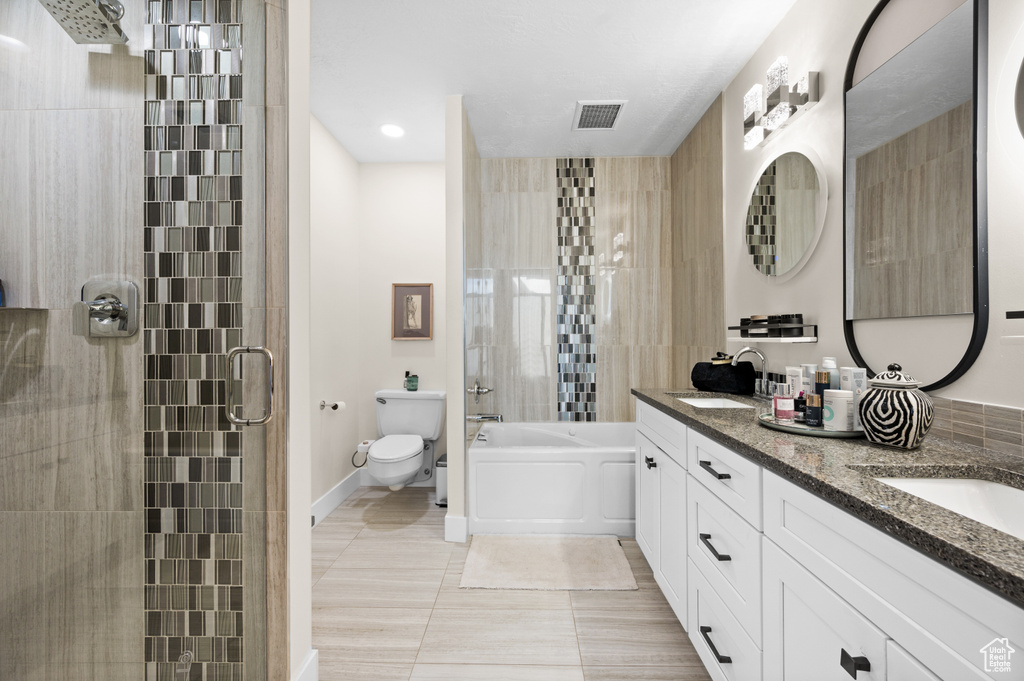 Full bathroom featuring toilet, shower with separate bathtub, vanity, and tile patterned flooring