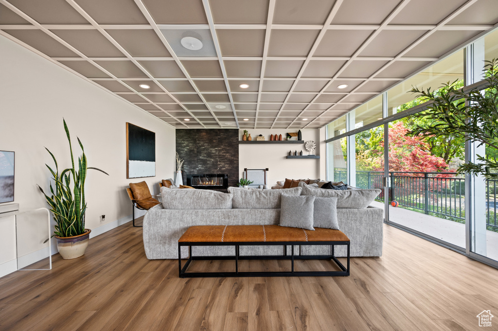 Living room with expansive windows, a large fireplace, and wood-type flooring