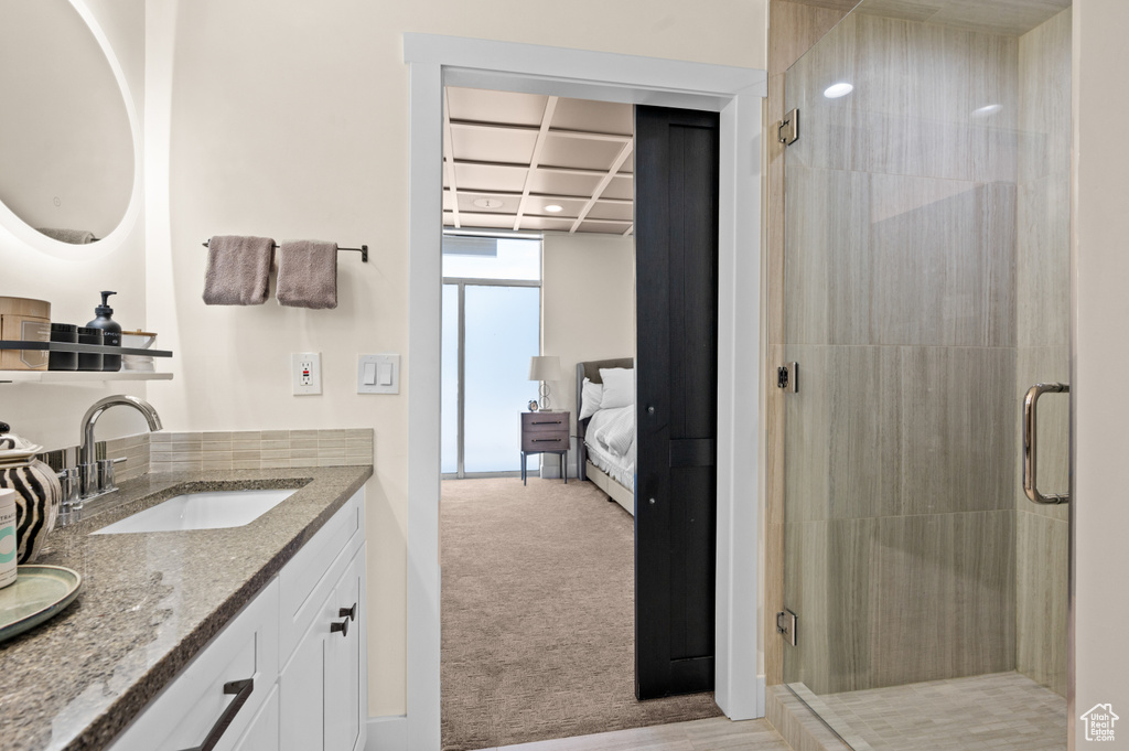 Bathroom with vanity, beamed ceiling, coffered ceiling, and a shower with door