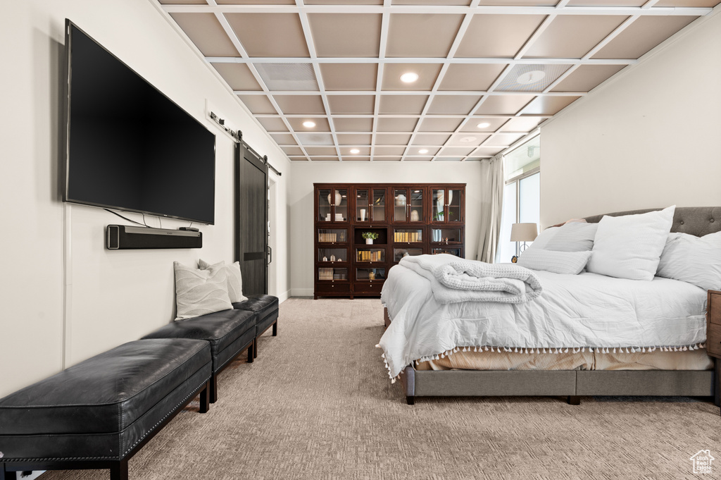 Carpeted bedroom featuring coffered ceiling and a barn door