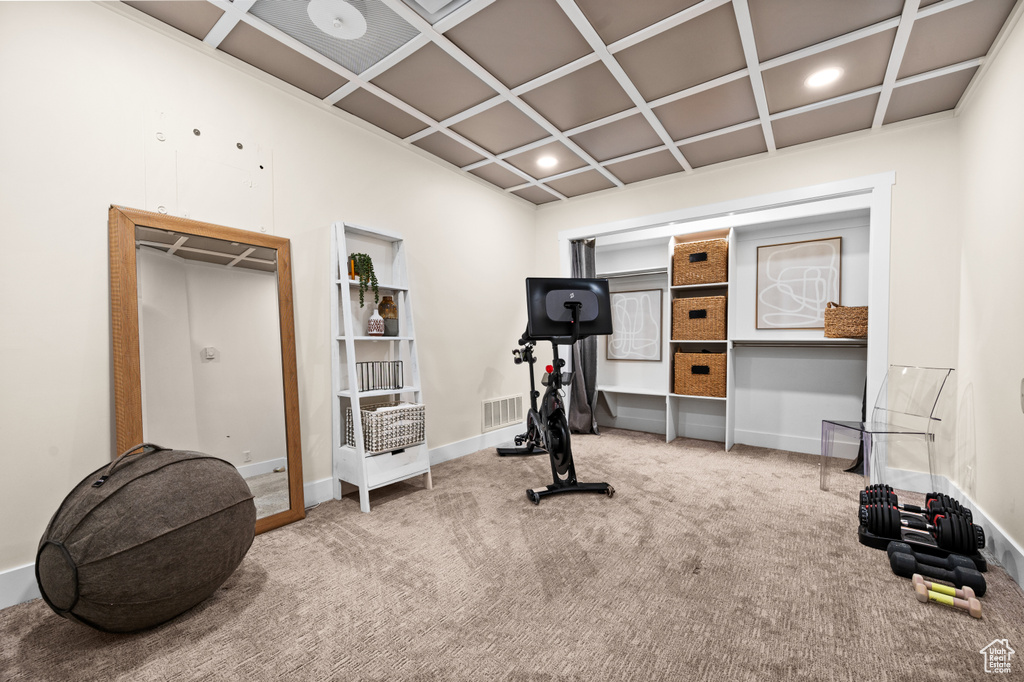 Workout room with coffered ceiling and carpet flooring