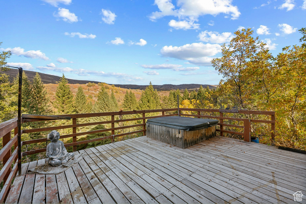 Deck with a mountain view and a covered hot tub