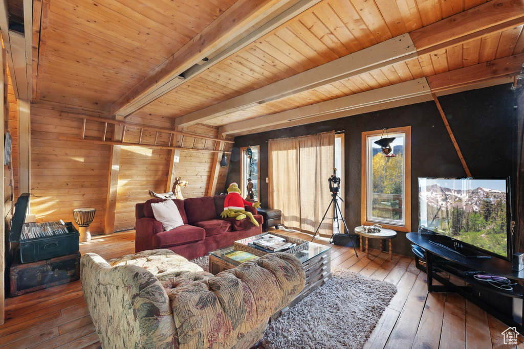 Living room with wood ceiling, wood walls, beam ceiling, and hardwood / wood-style floors