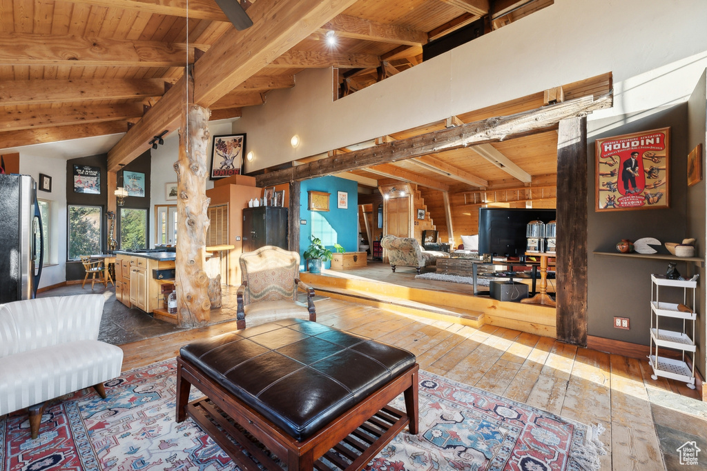 Living room featuring lofted ceiling with beams, wood-type flooring, and wooden ceiling