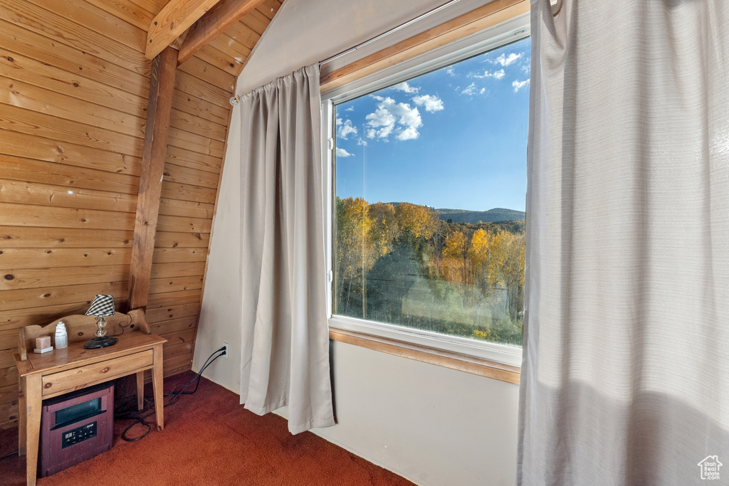 Interior details featuring beam ceiling, carpet flooring, wood ceiling, and wooden walls