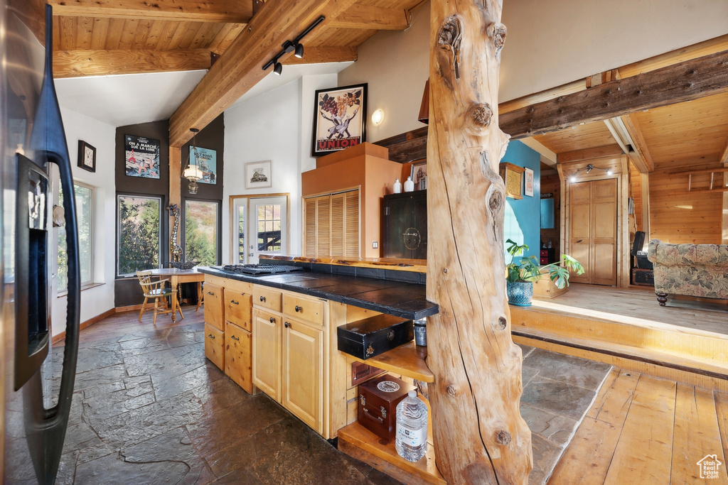 Kitchen featuring light brown cabinets, beam ceiling, wooden ceiling, refrigerator, and high vaulted ceiling