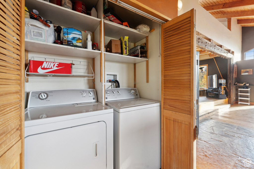 Laundry room with washer and dryer and light wood-type flooring