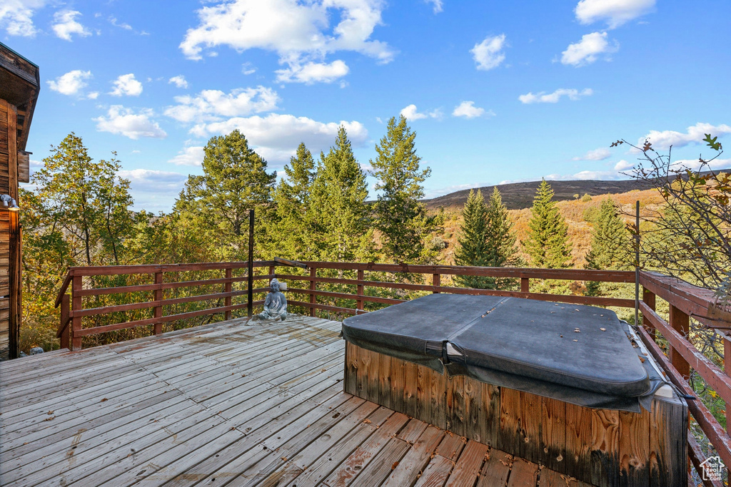 Wooden deck with a mountain view and a covered hot tub