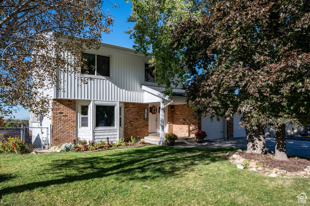 View of property with a front yard and a balcony