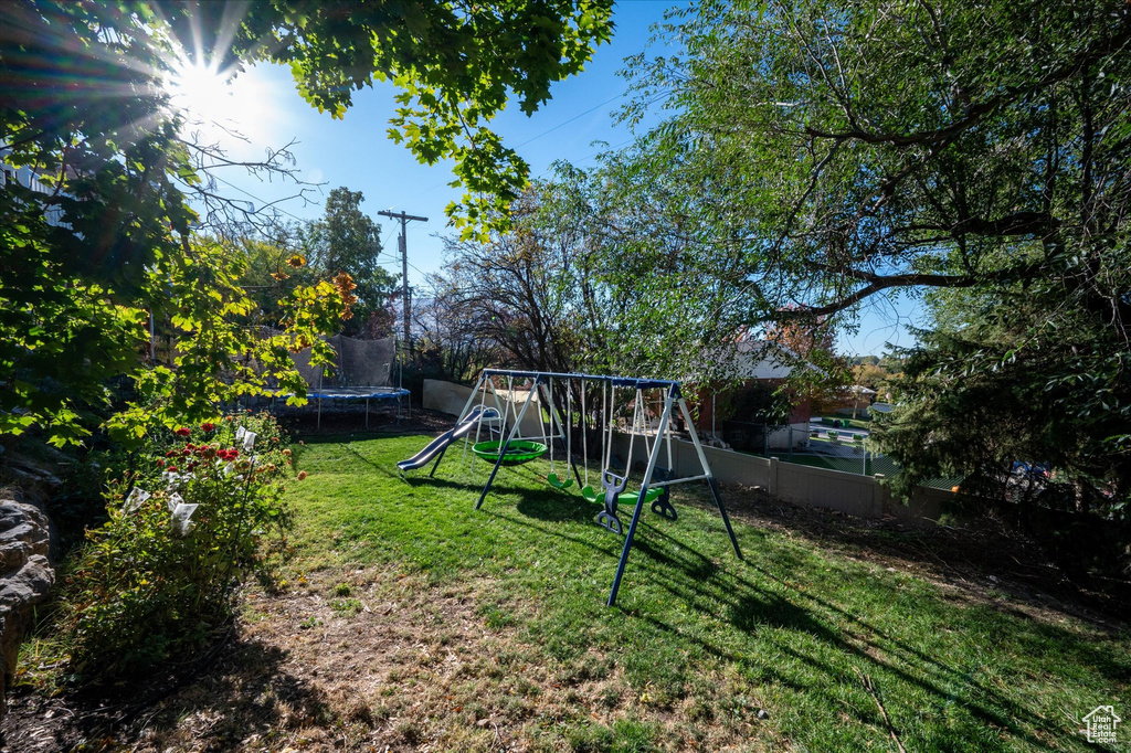 View of playground with a lawn and a trampoline