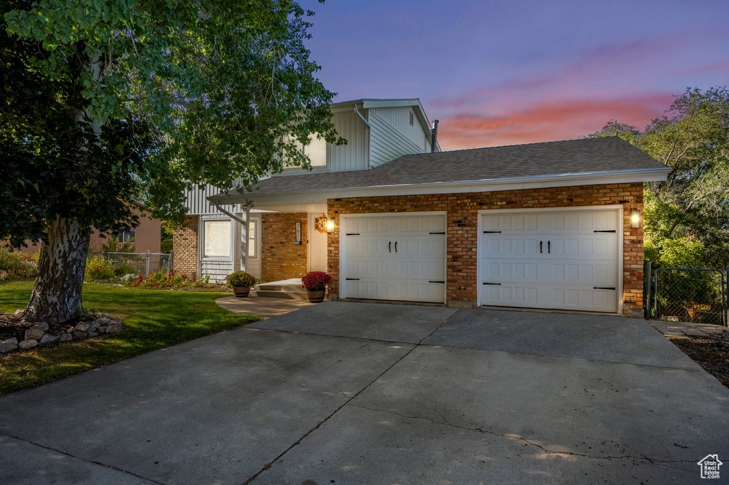 View of front property with a garage and a lawn