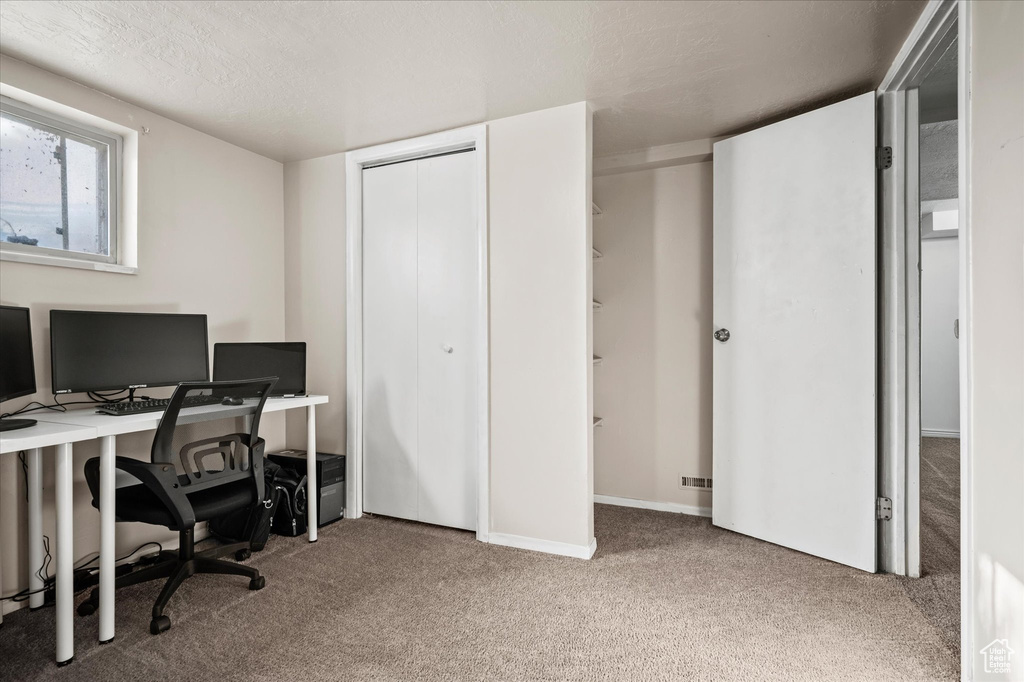 Carpeted office space featuring a textured ceiling