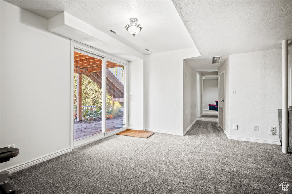 Carpeted spare room with a textured ceiling