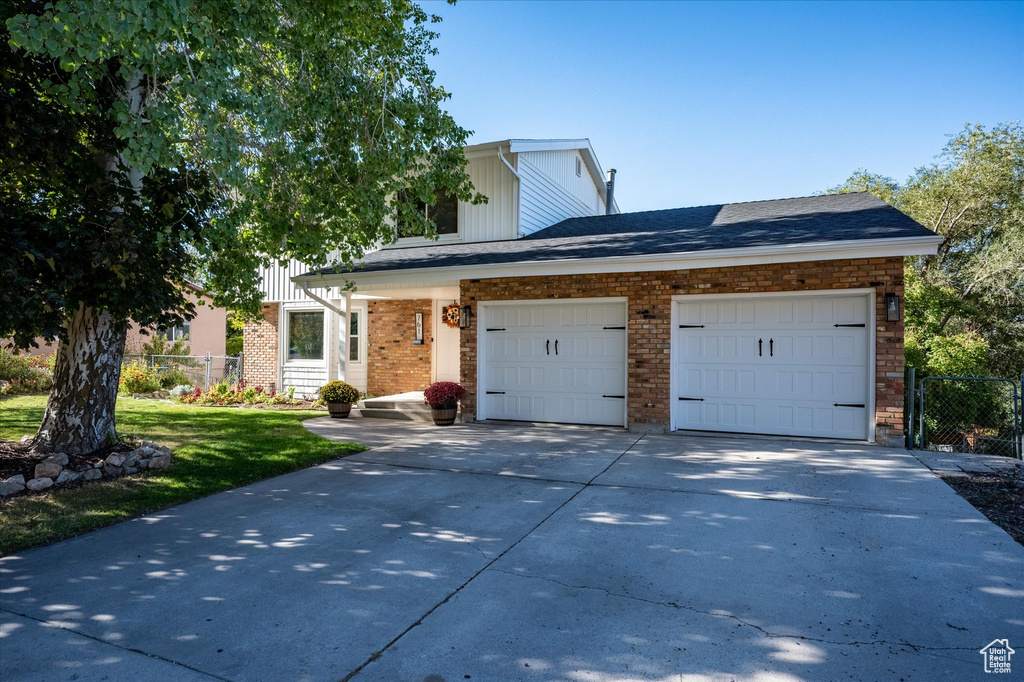 View of front of property featuring a front yard and a garage