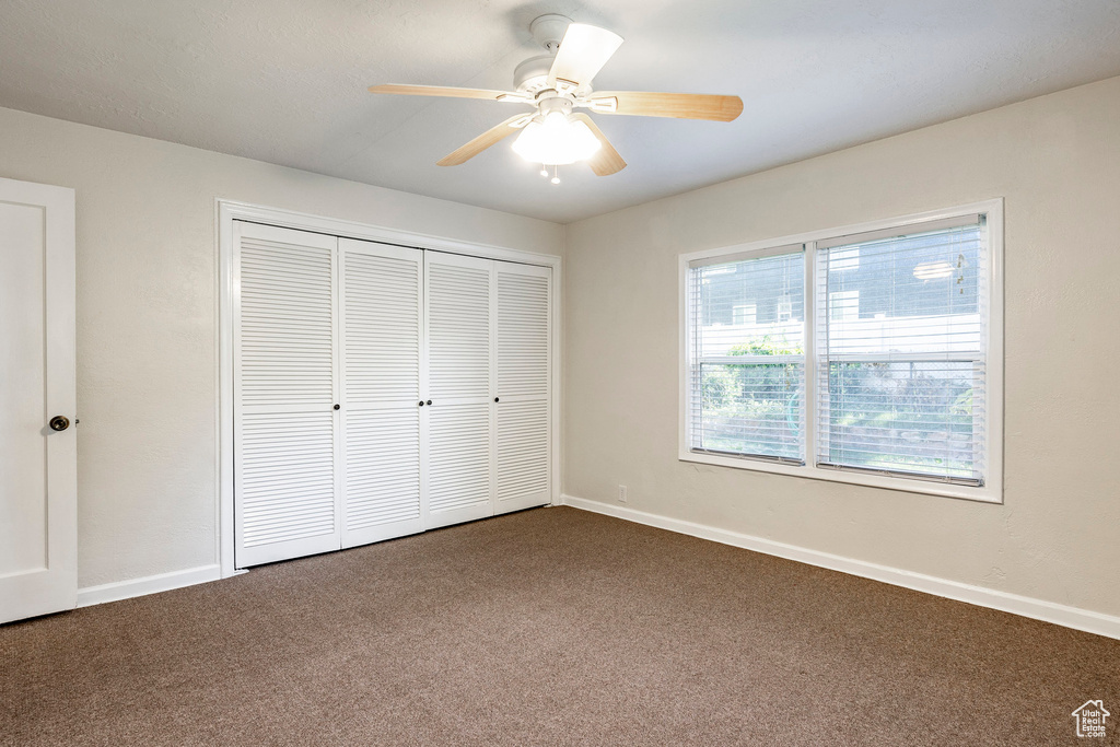 Unfurnished bedroom with carpet, ceiling fan, and a closet