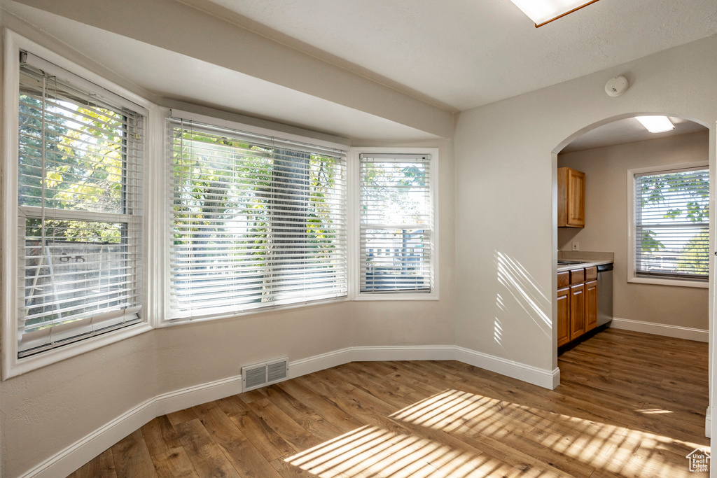 Unfurnished dining area featuring a wealth of natural light and dark hardwood / wood-style floors