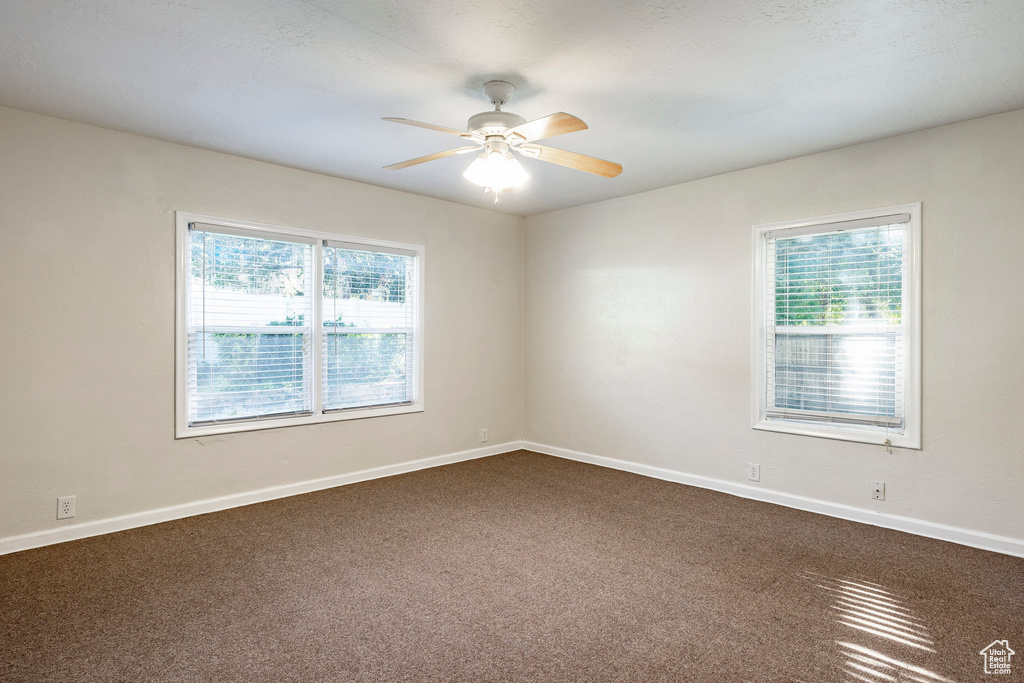 Carpeted spare room featuring ceiling fan