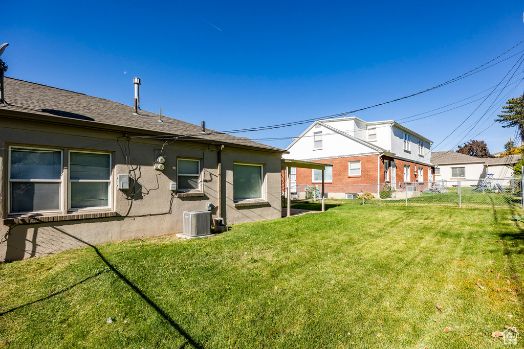 Back of property featuring central air condition unit, a patio area, and a yard