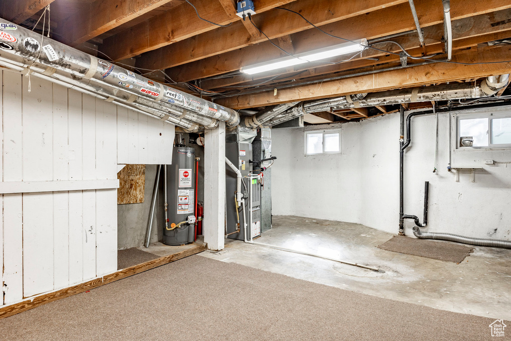 Basement featuring water heater and heating unit