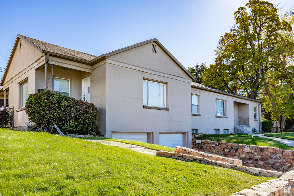 View of front of home with a garage and a front lawn