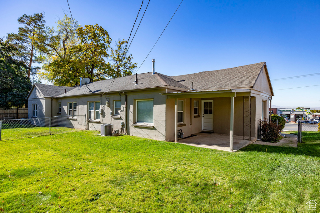 Back of house with a lawn, central AC, and a patio