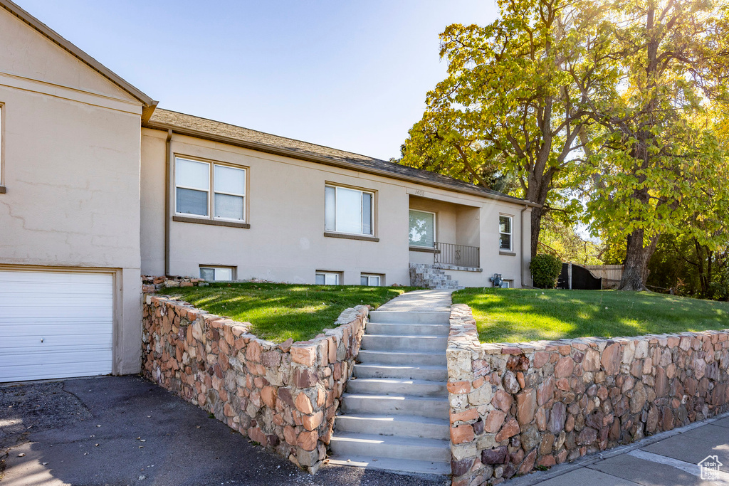 View of front of home featuring a front lawn and a garage