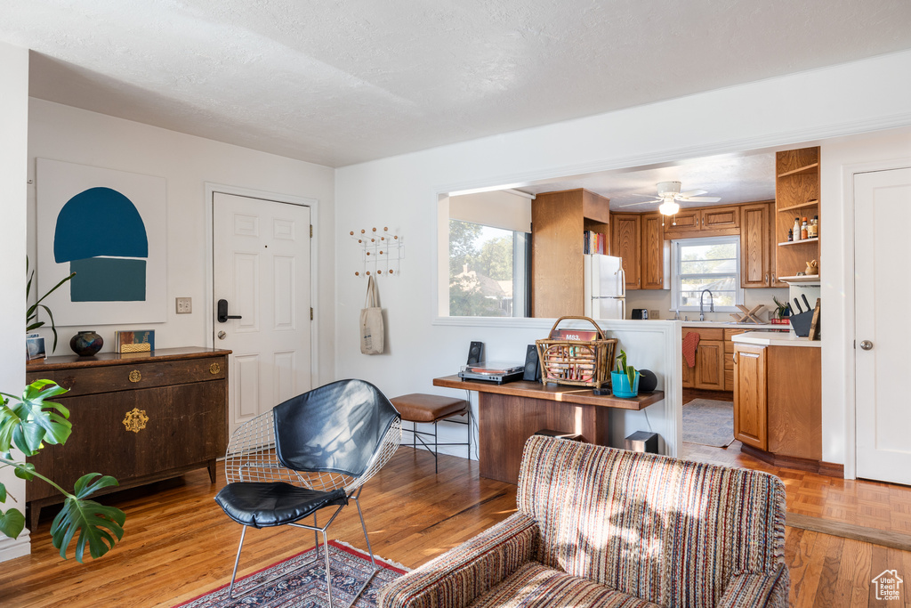 Interior space featuring white fridge, a textured ceiling, light wood-type flooring, and ceiling fan