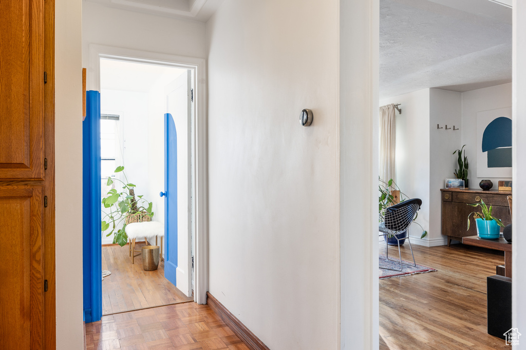 Corridor featuring a textured ceiling and light hardwood / wood-style flooring