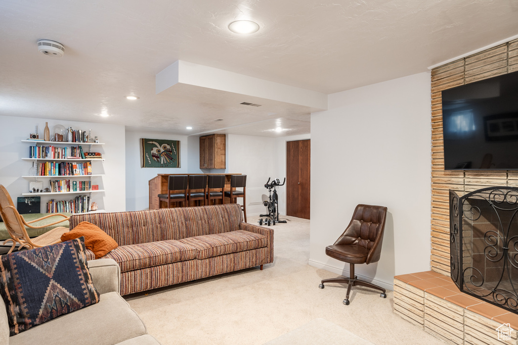 Living room with light carpet and a large fireplace