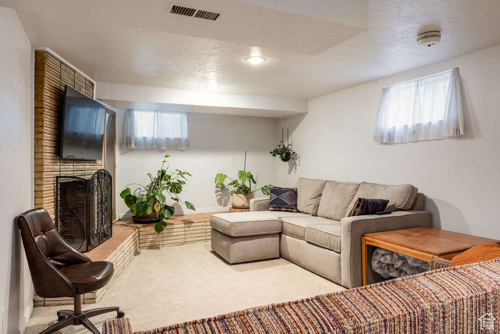 Living room featuring carpet flooring and a brick fireplace