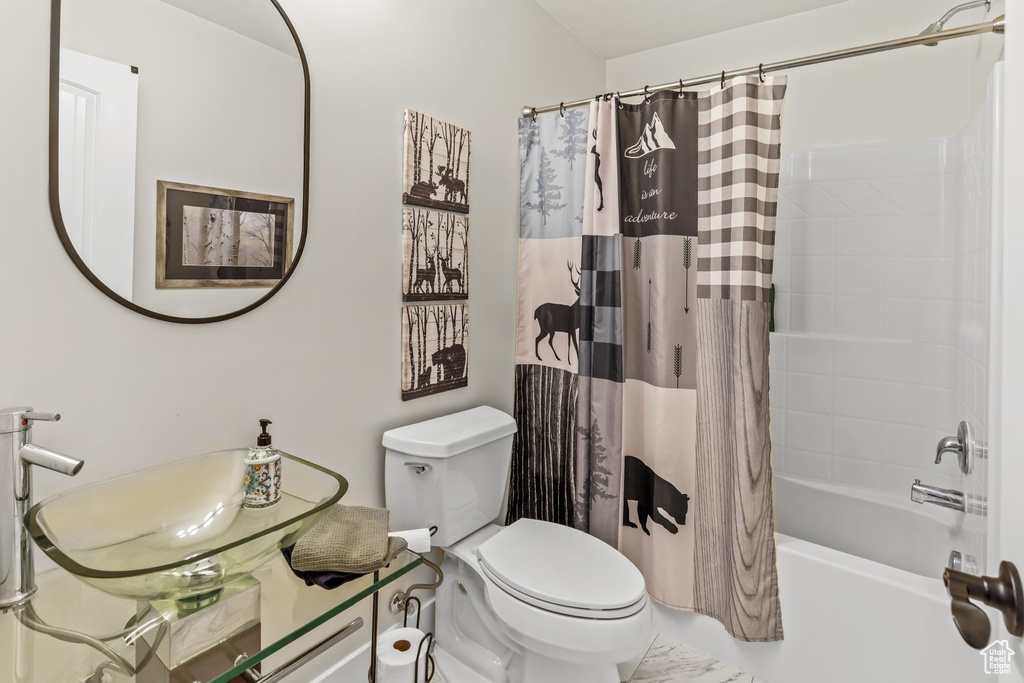 Full bathroom featuring shower / bath combination with curtain, toilet, and vanity