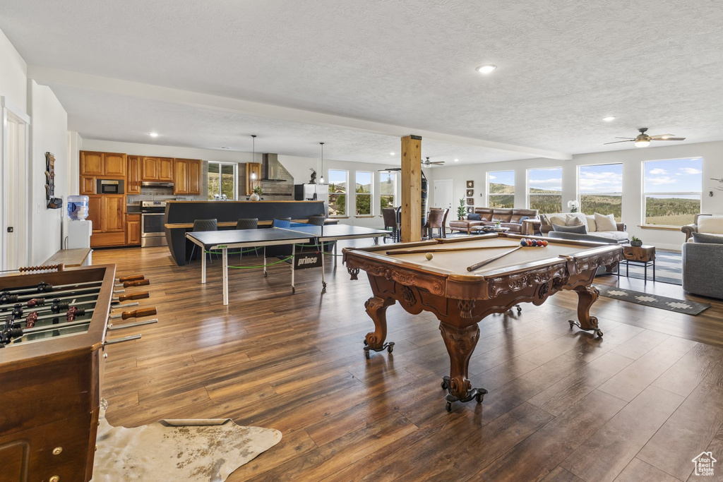 Game room with ceiling fan, hardwood / wood-style flooring, a textured ceiling, and plenty of natural light