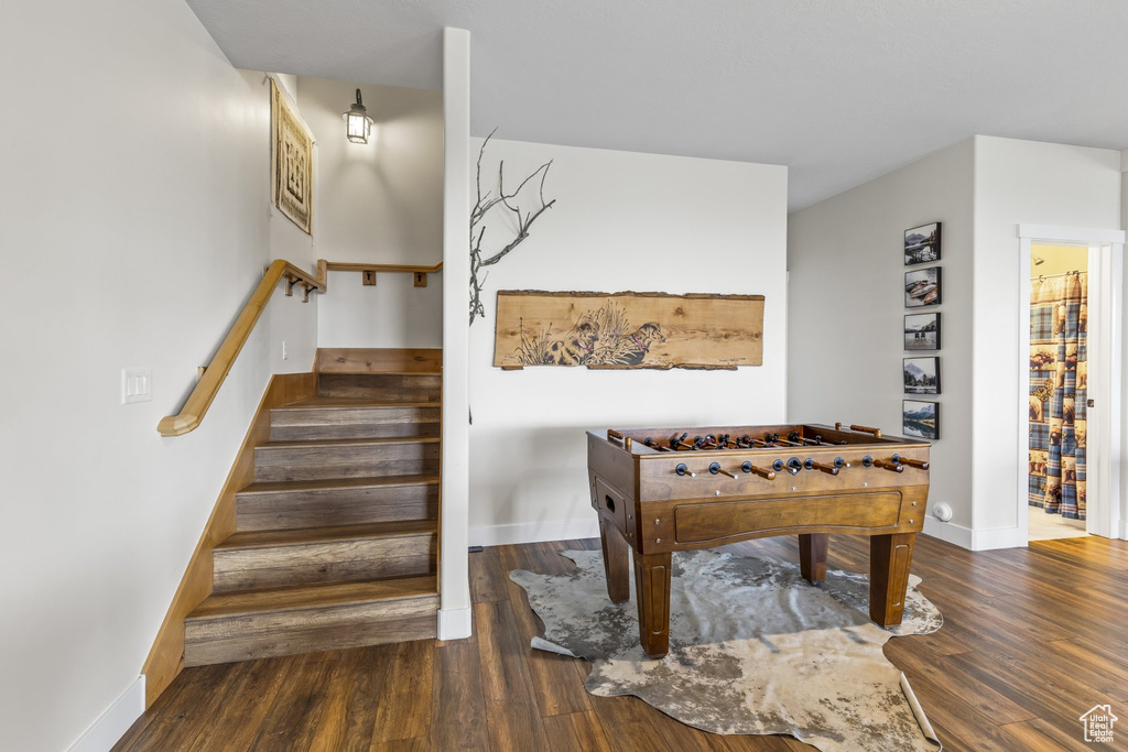 Game room with dark hardwood / wood-style floors