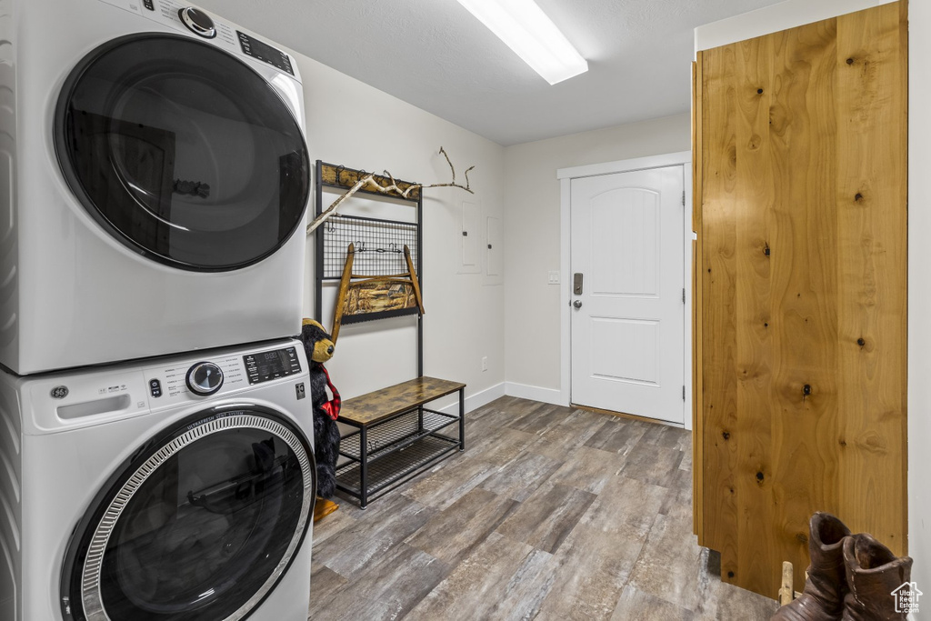 Washroom featuring stacked washer and dryer and hardwood / wood-style floors