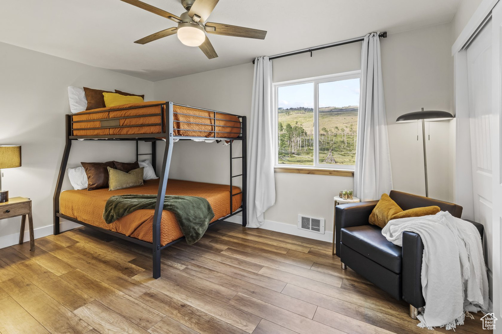 Bedroom with hardwood / wood-style flooring, a closet, and ceiling fan