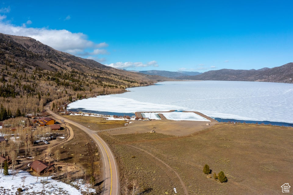 Snowy aerial view with a water and mountain view