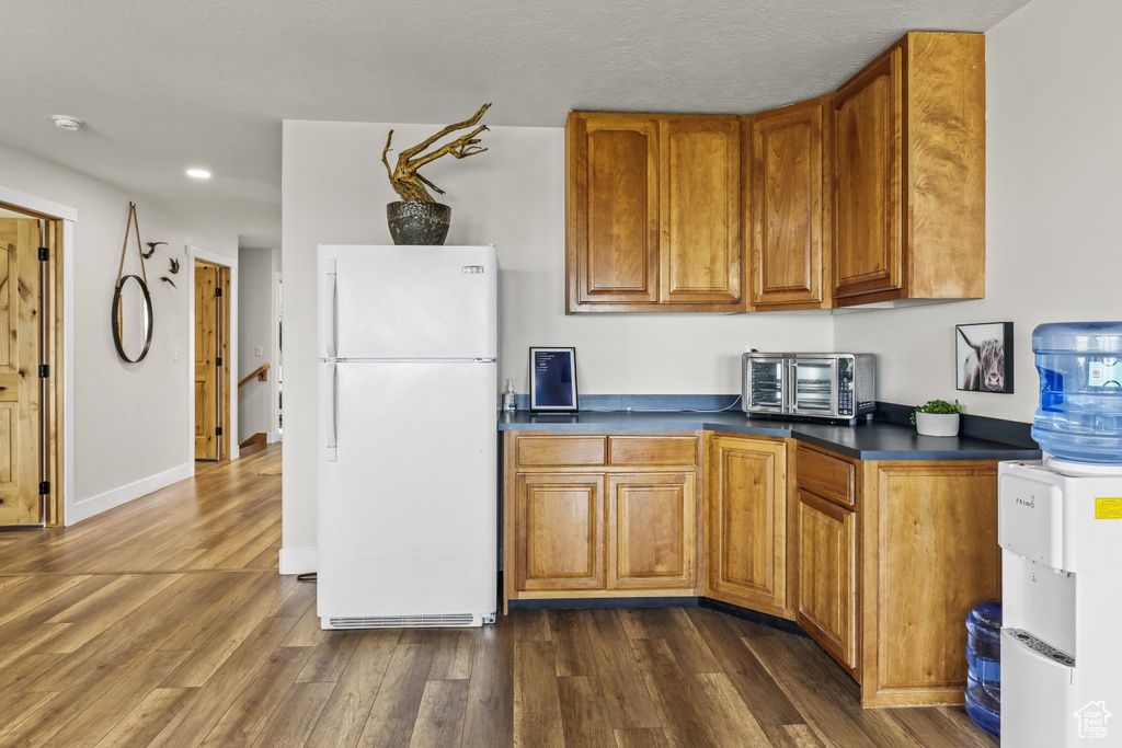 Kitchen featuring white fridge and dark hardwood / wood-style flooring