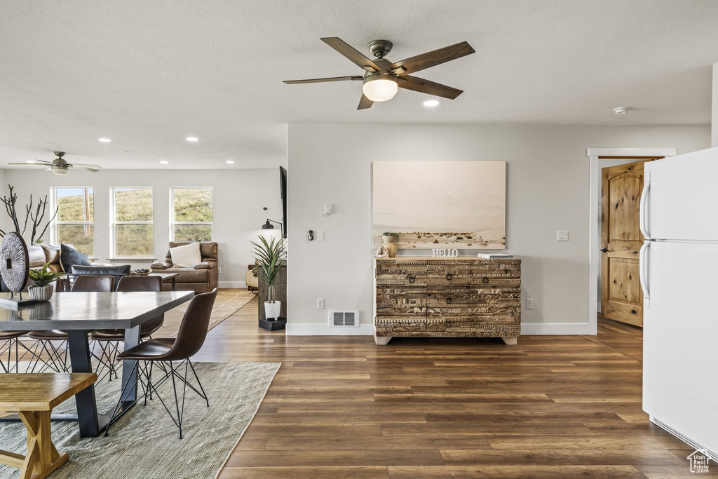 Dining space with dark hardwood / wood-style floors and ceiling fan