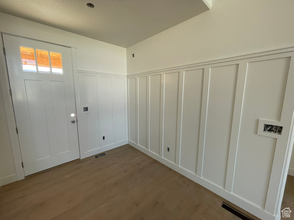 Clothes washing area with light hardwood / wood-style flooring