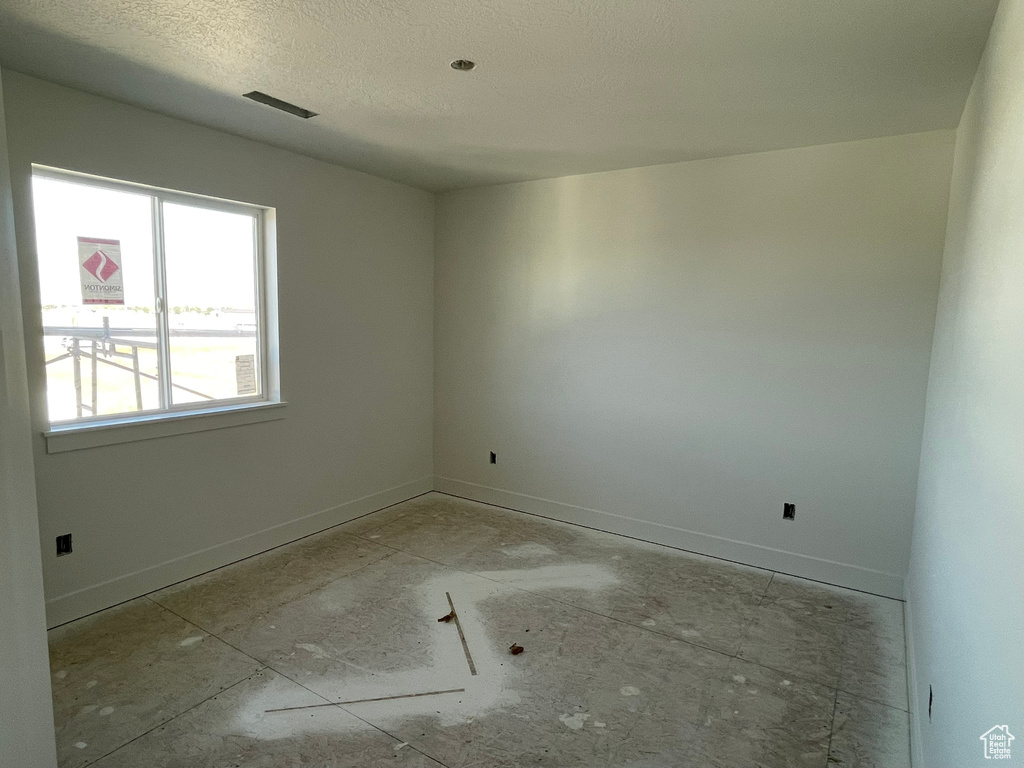 Unfurnished room with a textured ceiling