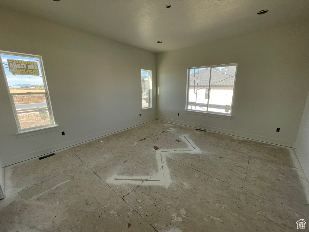 Unfurnished room featuring a healthy amount of sunlight