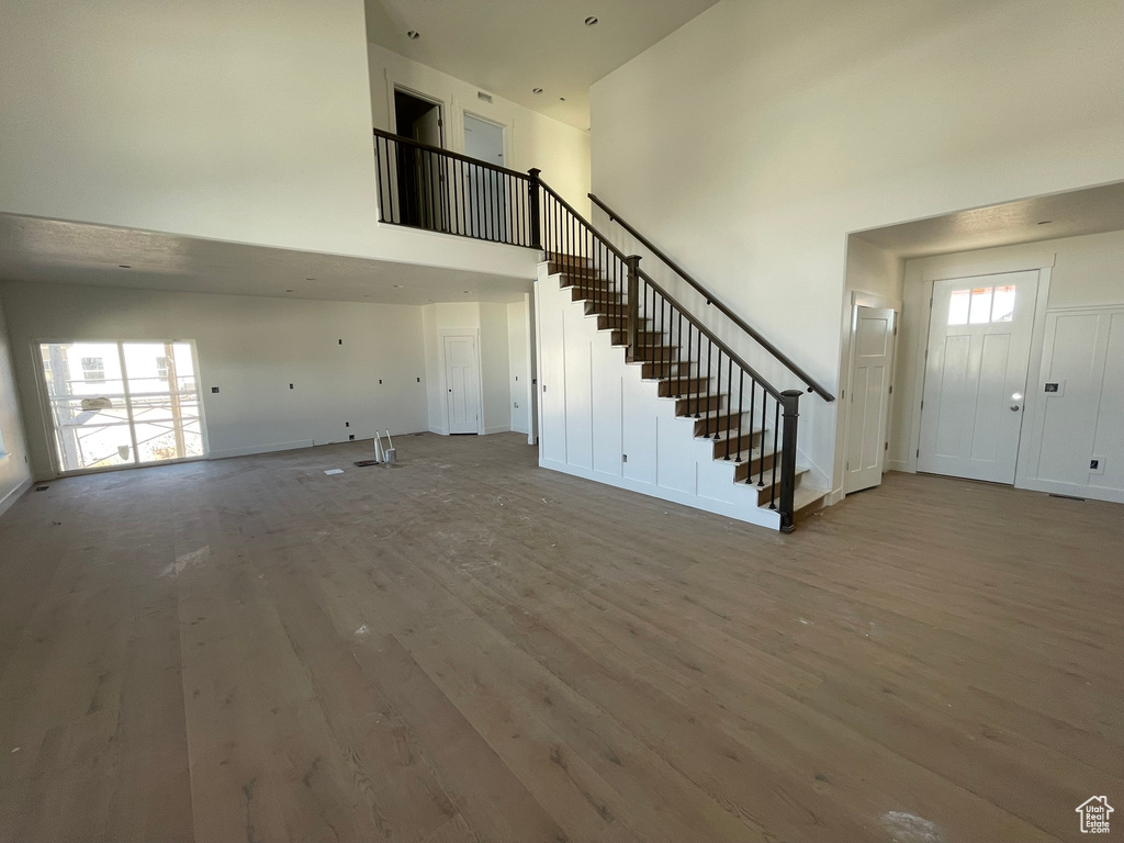 Entryway with a towering ceiling, hardwood / wood-style flooring, and plenty of natural light