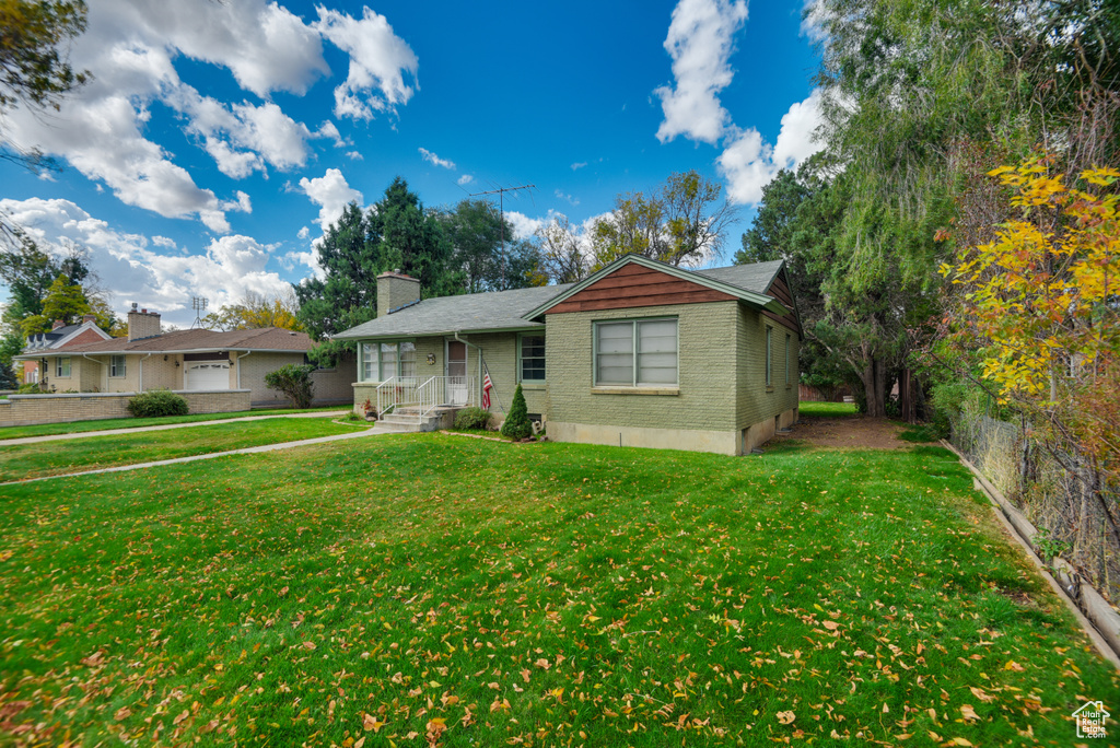 Single story home featuring a front yard and a garage
